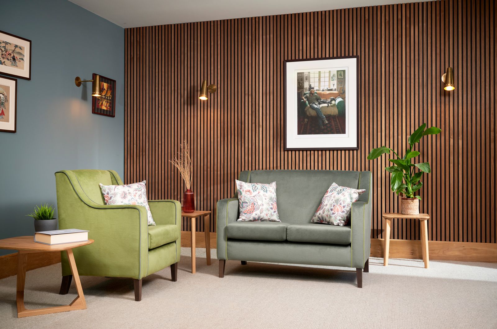 Belgravia Mid Armchair and Sofa in Green against a wooden panel wall